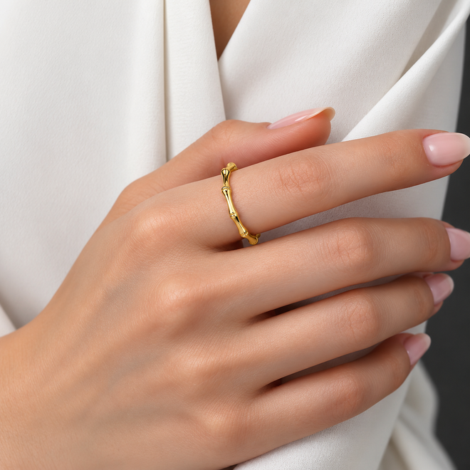14 ayar altın bambu yüzüğün kadın elinde duruşu. İnce bambu desenli tasarımı, parlak sarı altın işçiliği ve zarif görünümüyle Kairos Jewelry yüzük modeli.